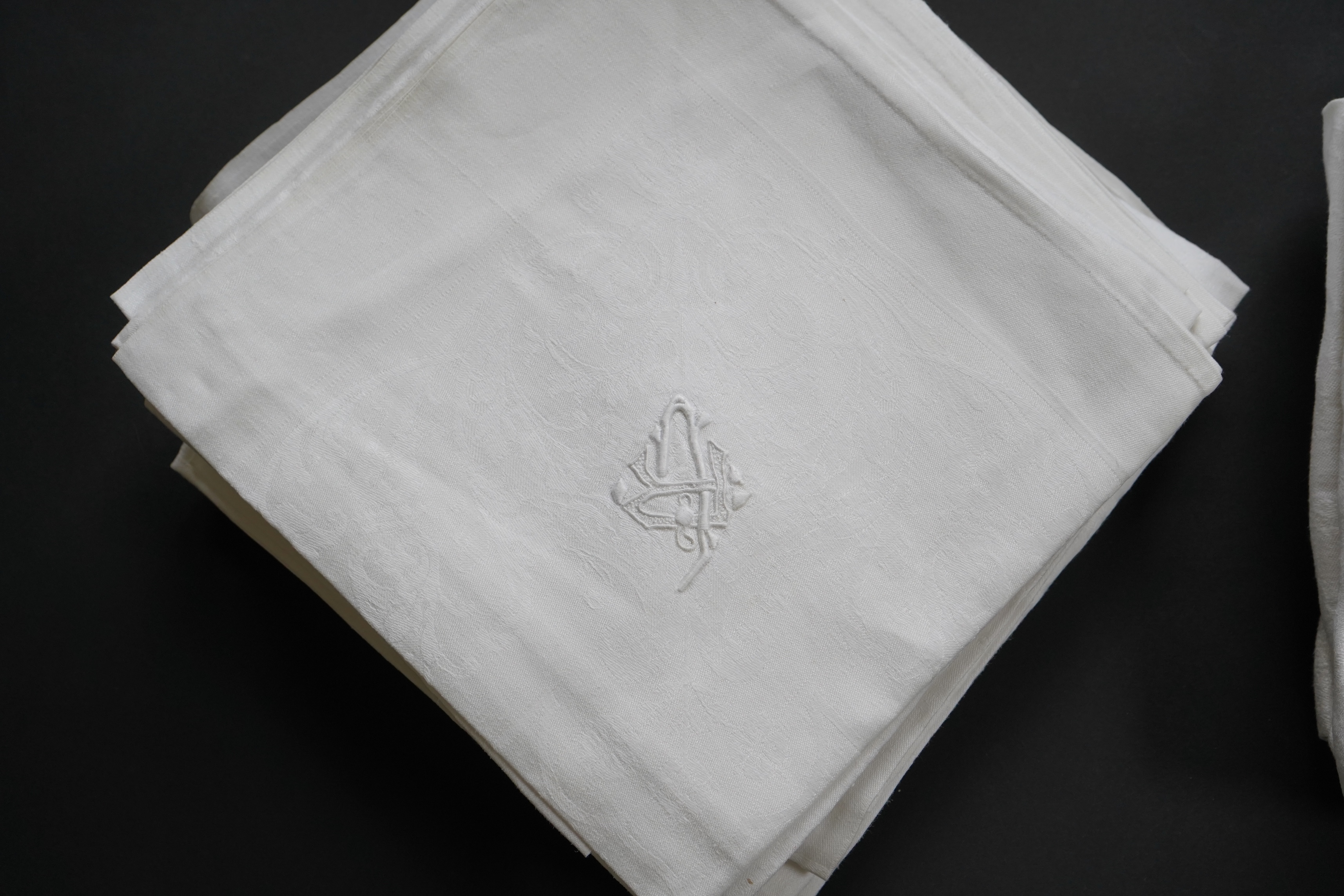 A set of fifteen large 19th century monogrammed damask dinner napkins and set of eight similar sized monogrammed damask dinner napkins, the larger set designed with a wide classical scrolling floral border and a simple d